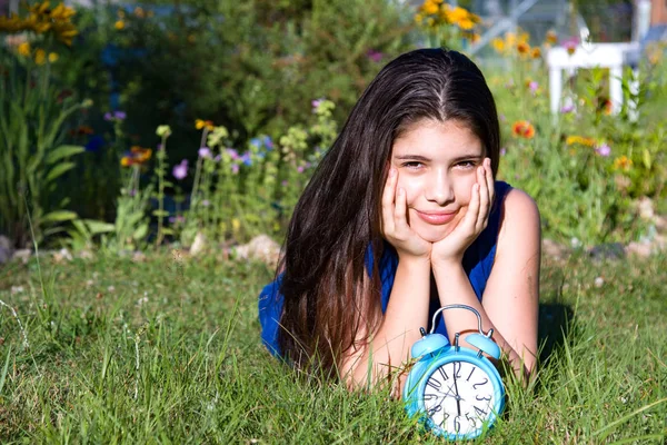 Girl with blue alarm clock in summer — Stock Photo, Image
