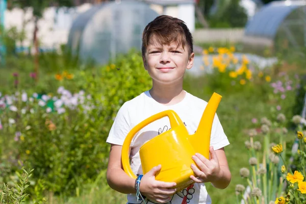 Netter Junge mit Gießkanne im Garten — Stockfoto