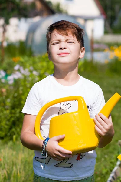 Lindo chico con regadera en el jardín — Foto de Stock