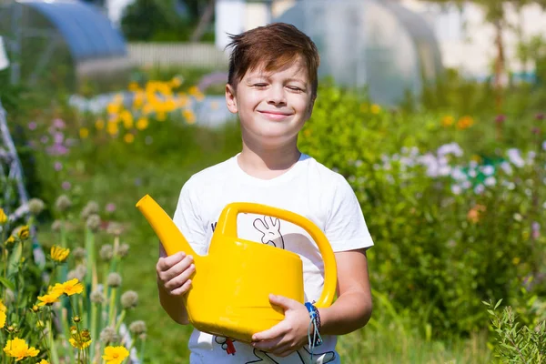 Netter Junge mit Gießkanne im Garten — Stockfoto