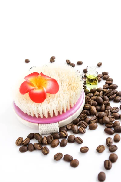 Body brush, flower,coffee beans and oil on white background