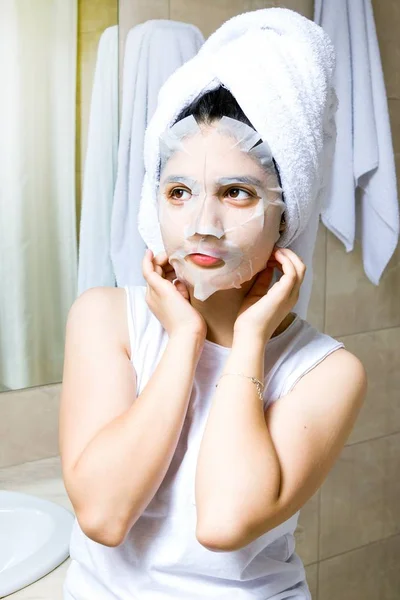 Girl with facial mask in bedroom. Cosmetic procedure. — Stock Photo, Image