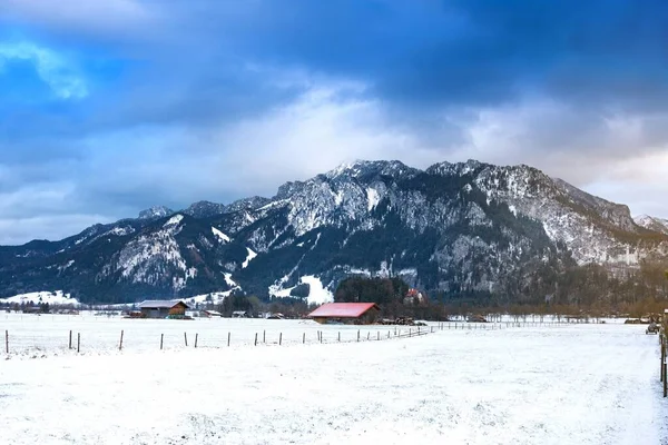 Dřevěná Bouda Zasněženém Poli Proti Alpám Zimním Dni Schwangau Bavorsko — Stock fotografie