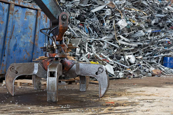 在有大型抓斗的废品堆场上使用过的金属碎片 — 图库照片