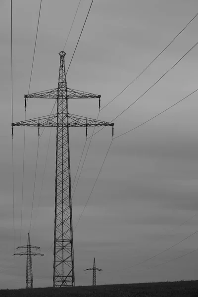ケーブルと劇的な空を持つ高電圧パイロン — ストック写真