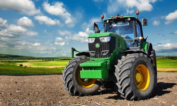 Современный, зеленый трактор в весенне-полевых работах — стоковое фото