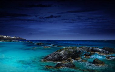 gece deniz, okyanus doğal olarak arka plan Kuzey ışıkları kayalar ve taşlar ve okyanus manzarasına. Güzel deniz su renk ve ışık ile oynar. Ay ışığı