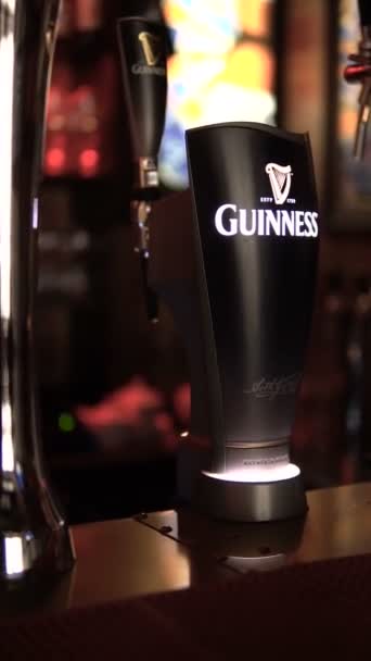 Pjatigorsk, Rusko-říjen 8, 2018: barman nalévá originální Guinness piva do sklenice. Vertikální videa pro příběhy. — Stock video