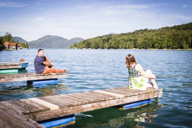 Tatil bir göl kenarında iskelede iki mutlu lovers