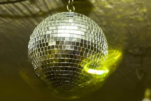 A party with disco ball with yellow lights
