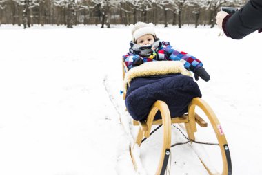 Ormandaki karda kızakla bir bebek