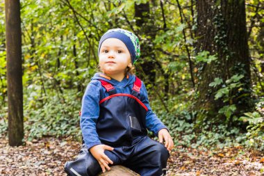 Bebek sonbaharda bir orman yolda oynuyor