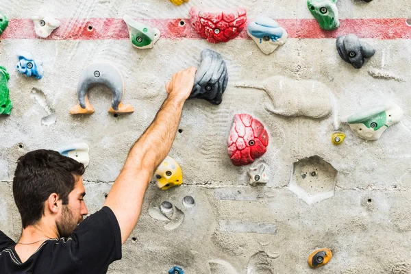 Homme pratiquant l'escalade sur un mur artificiel à l'intérieur. Actif — Photo