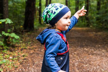 Bebek sonbaharda bir orman yolda oynuyor