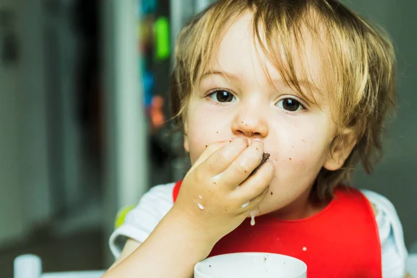 Portrait adorable child eating chocolate sponge cake — Stock Photo, Image