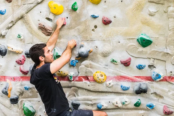 Homme pratiquant l'escalade sur un mur artificiel à l'intérieur. Actif — Photo