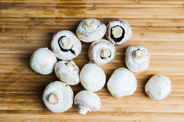Cogumelos brancos em tábua de madeira — Fotografia de Stock