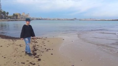 Genç koyu kız deniz yaklaşırken bir seçme için poz veriyor