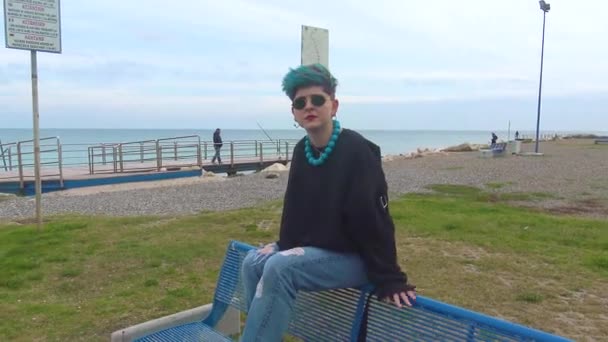 年轻的黑暗女孩坐在城市海滩的长椅上摆姿势参加海选 — 图库视频影像