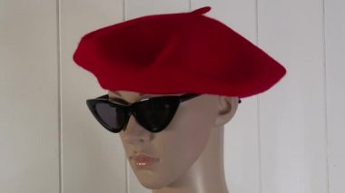 Kadın manken, 4K 50 fps 'lik bir Bask şapkasıyla moda videosu için yakın plan poz veriyor.