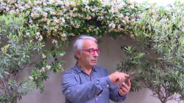 スマートフォンで話している間にポーズをとっているイタリア人ヨーロッパ人の男性のクローズアップ タイムラプス — ストック動画