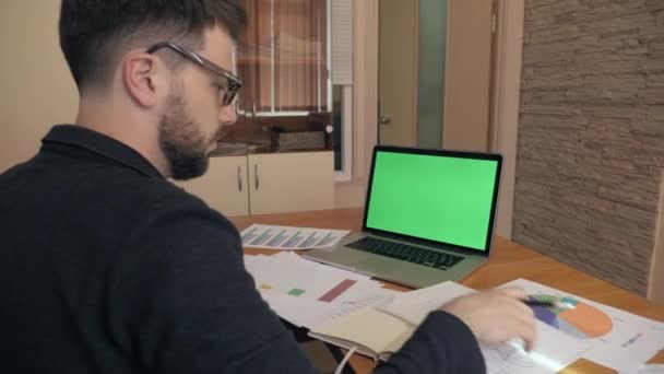 Orta atış başarılı adam iş istatistikleri ile yeşil ekran laptop — Stok video