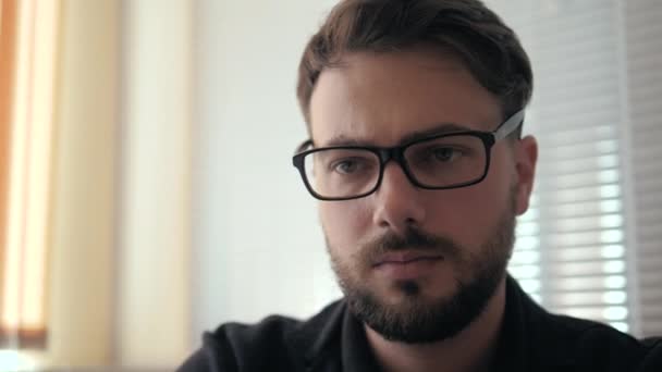 El primer plano del hombre joven exitoso que trabaja en el portátil con las estadísticas en las gafas — Vídeos de Stock
