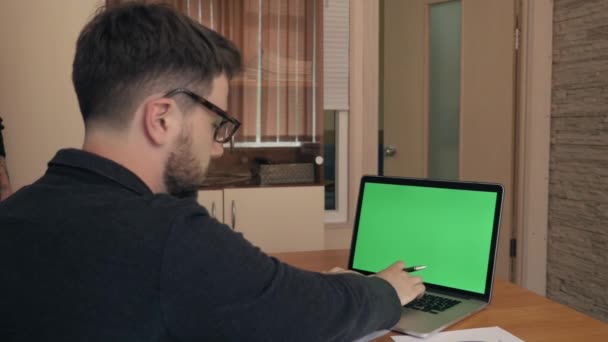 Mittlere Aufnahme eines erfolgreichen jungen Mannes, der mit Statistiken am Laptop arbeitet — Stockvideo