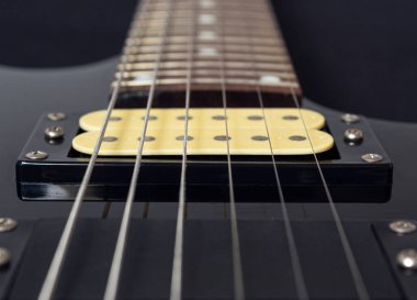 Altı elektro gitar teli, ahşap pano ve mikrofonlara yakın çekim. Aletler ve müzik konsepti