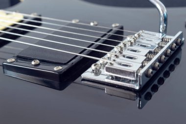 Altı tane siyah elektro gitar teli ve mikrofona yakın çekim. Aletler ve müzik konsepti