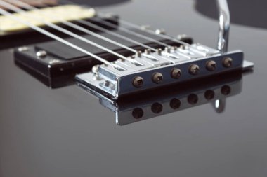 Altı tane siyah elektro gitar teli ve mikrofona yakın çekim. Aletler ve müzik konsepti