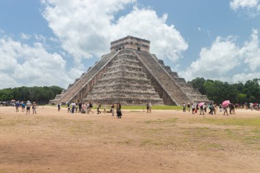 Bir grup turist, Chichen Itza arkeoloji sahasına girip kale tapınağının önünde fotoğraf çekiyorlar.