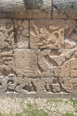 Elinde insan kafası olan savaşçı bir top oyuncusunu Chichen Itza arkeolojik sitesinde temsil eden Maya oyma taşına yakın bir yerde.