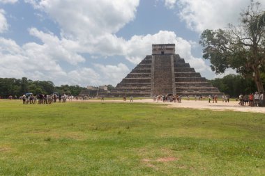 Güneşli bir günde Chichen Itza arkeolojik alanının turist grupları ve savaşçı tapınaklarıyla güzel bir manzara görüntüsü.