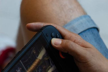 Nintendo düğmelerine ve joystick 'e basan bir erkeğe yaklaş