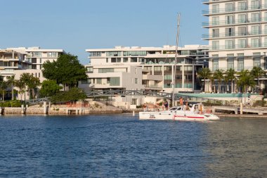 Cancun Mexico 'da güneşli bir günbatımında Puerto marinası olarak bilinen zengin bir mahallede kanala yelken açan bir katamaran.