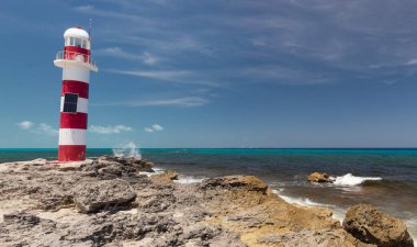 Sol taraftaki eski bir fenere ve güneşli bir günde arka plandaki Atlantik okyanus manzarasına yakın.
