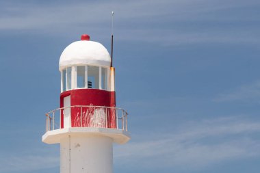 Güneşli bir günde arka planda mavi gökyüzü olan antik bir fenerin tepesine yakın.