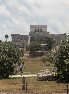 Tulum arkeolojik bölge olarak bilinen antik Maya kalıntılarının yanında yürüyen güzel güneşli bir ziyaretçi sahnesi.