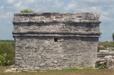 Tulum arkeolojik bölgesinde güneşli bir günde küçük bir penceresi olan antik Maya tapınağının ön cephesine yakın.