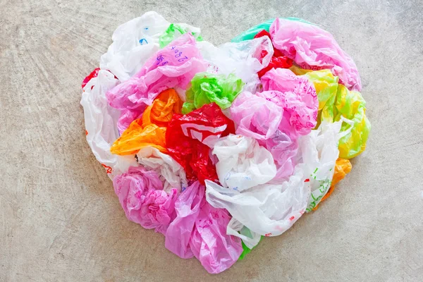 Colorful plastic bag on cement floor background. Heart Shape. Top view