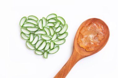 Aloe vera dilimleri kalp şeklinde beyaz zemin üzerine tahta kaşıkla üzerinde Aloe vera jel