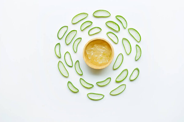 Aloe vera slices with aloe vera gel on wooden bowl isolated on white  background.