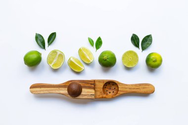 Beyaz arka plan üzerinde ahşap limon sıkacağı ile Limes