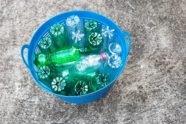 Plastic bottles in blue waste basket.