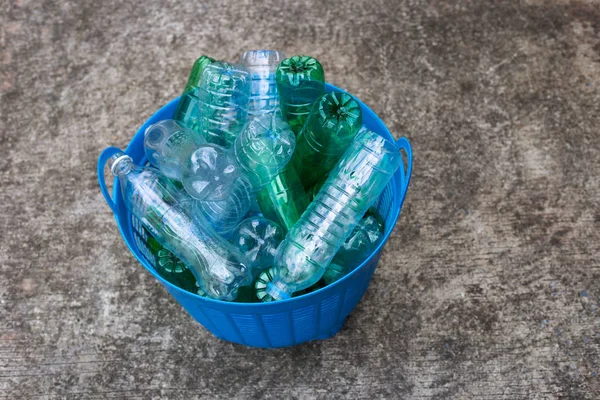 Plastic bottles in blue waste basket.