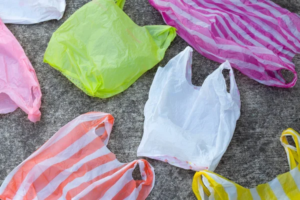 Colorful plastic bags on cement floor background