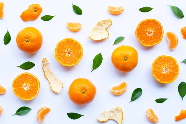 Fresh orange citrus fruit with peel and green leaves on white background.