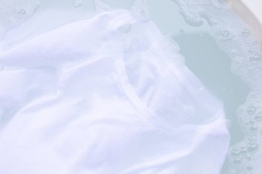 Bir kumaş yıkama önce beyaz T-shirt emmek