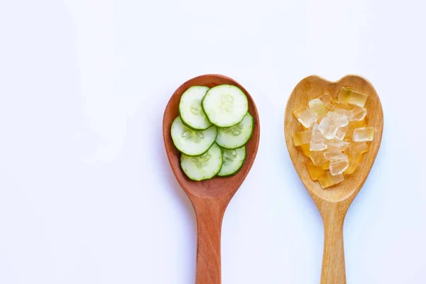 Cucumber slices with aloe vera gel in wooden spoon on white background for homemade skin care. Copy space